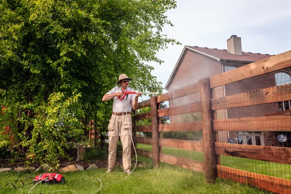 El hombre está limpiando la cerca de madera — Foto de Stock