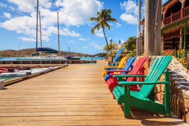 Parlak renkli adirondack sandalyeler üstünde bir rıhtım