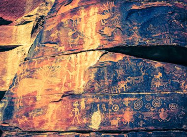 Indian petroglyphs on a rock face clipart
