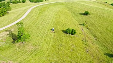 Aerial view of a tractor mowing grass field on a pasture in Central Kentucky