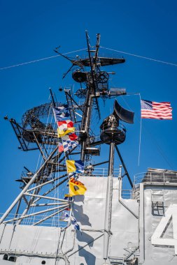 Bir askeri geminin direğinde radar ekipmanı ve bayraklar.