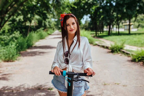 Cute Brunetka Dziewczyna Jeździ Skuterze Elektrody Parku Sobie Białą Koszulę — Zdjęcie stockowe