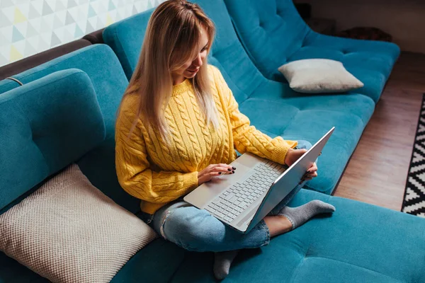 Een Vrouw Met Een Laptop Een Gele Trui Zit Bank — Stockfoto