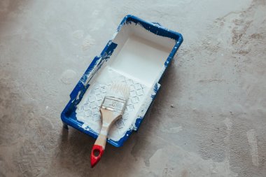 Beyaz boya konteynırında inşaat fırçası.