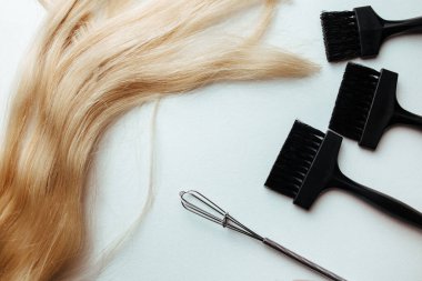 a broom and a brush for dyeing hair on a white background. hair coloring concept and parekmahep instrument