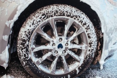 front wheel in soapy foam. self-service car wash concept