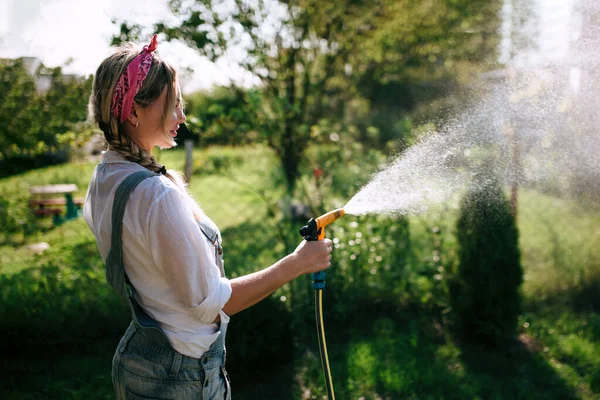 Young Woman White Shirt Denim Overalls Watering Lawn Gardening Concept — Stok Foto