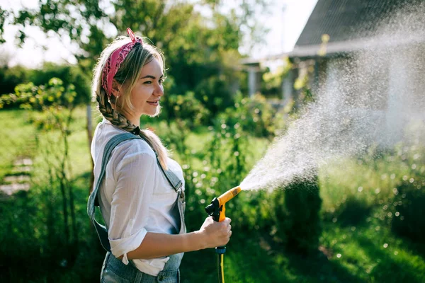 Young Woman White Shirt Denim Overalls Watering Lawn Gardening Concept — Stockfoto