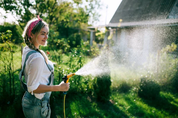 Young Woman White Shirt Denim Overalls Watering Lawn Gardening Concept — Stok Foto