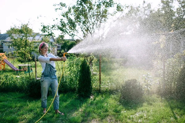 Young Woman White Shirt Denim Overalls Watering Lawn Gardening Concept — Stok Foto