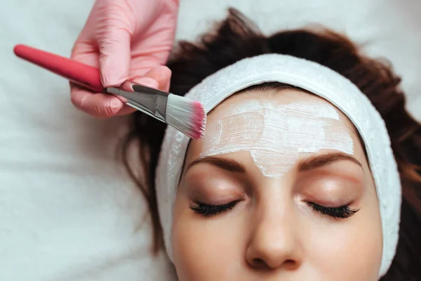 applying cream to the skin of a model in a spa salon close-up