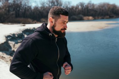 Erkek koşucu kumda egzersiz yapıyor. Doğadaki koşu konsepti. yakın plan