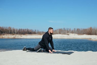 Sporcu doğada antrenman yapmadan önce bacaklarını açıyor.