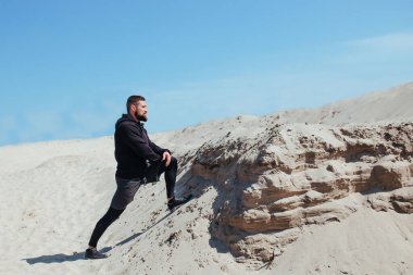 Sporcu doğada antrenman yapmadan önce bacaklarını açıyor.