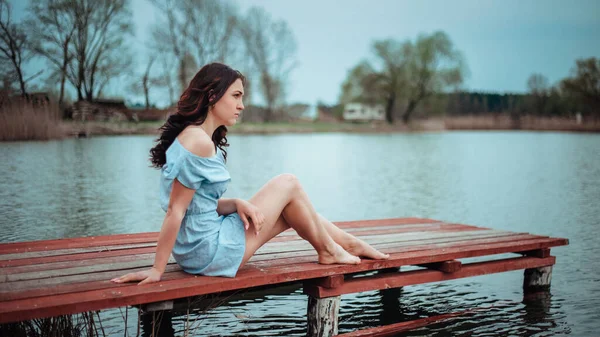 Eine Frau Einem Hellschwarzen Kleid Sitzt Auf Der Seebrücke — Stockfoto