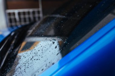 Arabanın ön camına su damlıyor. araba yıkama konsepti