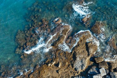 Hava görüntüsü. Akdeniz Türkiye 'nin dalgaları kayaları dövdü. Turkuaz deniz suyu dalgaları yükseklerde çekilir.