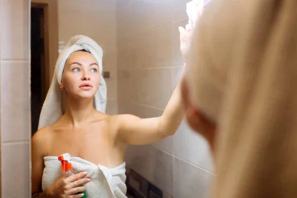 샤워실 청소하고. 아름다운 소녀가 헝겊으로 거울을 닦다 — 스톡 사진
