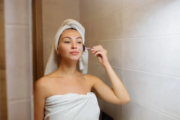 温泉和化妆品学。面部皮肤护理在家里。浴室里的女孩用奶油面罩 — 图库照片