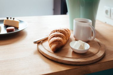 Bir kruvasan kahve ve tereyağı pencere eşiğinde durur. . 