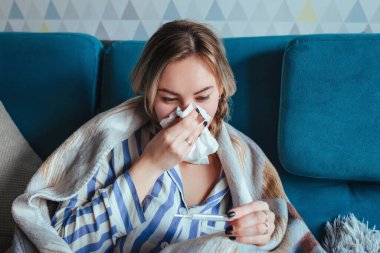 Ginseng sırıtarak peçeteye bakar ve termometreye bakar. Hastalık ve salgın konsepti