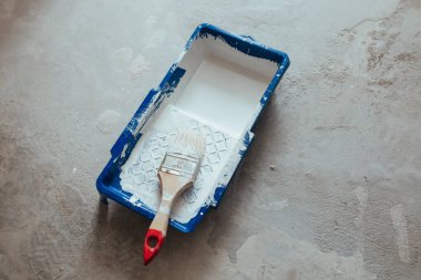 Beyaz boya konteynırında inşaat fırçası