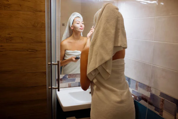 スパと美容室 自宅で顔の皮膚ケア 浴室の女の子はクリームフェイスマスクを適用します — ストック写真