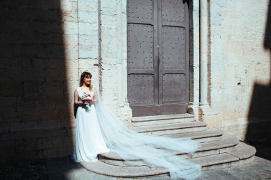 Düğün için. Gelin elinde bir buketle damadı bekliyor. Yeni evlilerin kilisede buluşması.. 