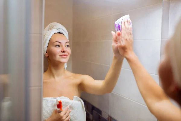 샤워실 청소하고 아름다운 소녀가 헝겊으로 거울을 — 스톡 사진