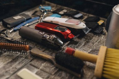 Profesyonel tımar aletleri ve elektrikli makasıyla berber çalışma yerinde. Kuaför vagonundaki kuaförlük ekipmanlarını kapat, saç kesimi hazırlığı, modern berber dükkanı iç mekanı.