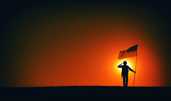 Soldado de EE.UU. con bandera saludando en el horizonte del atardecer —  Fotos de Stock