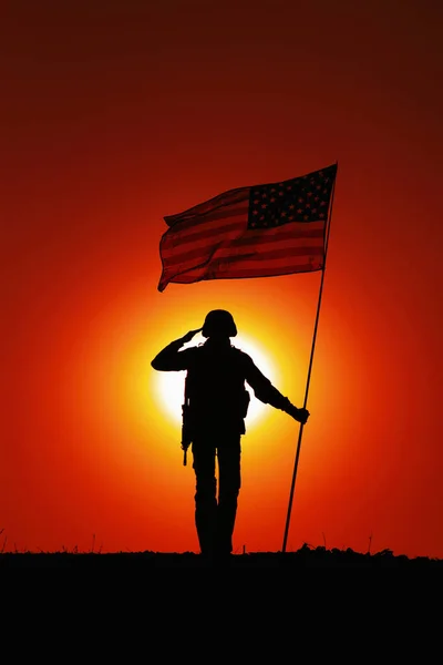 Soldado de EE.UU. con bandera saludando en el horizonte del atardecer — Foto de Stock