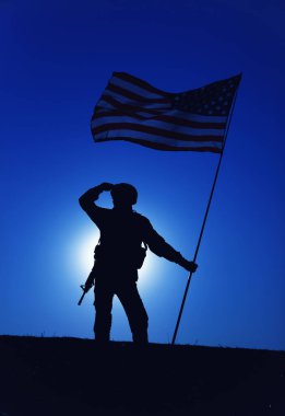 Bayrağıyla selamlayan Amerikan askerinin silueti