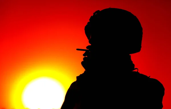 Silhouette of smoking on sunset army soldier — Stock Photo, Image