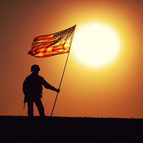 Soldado del ejército de EE.UU. con bandera en el fondo del atardecer — Foto de Stock