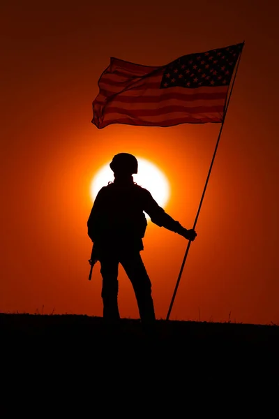 日没の背景に旗を持つアメリカ軍兵士 — ストック写真