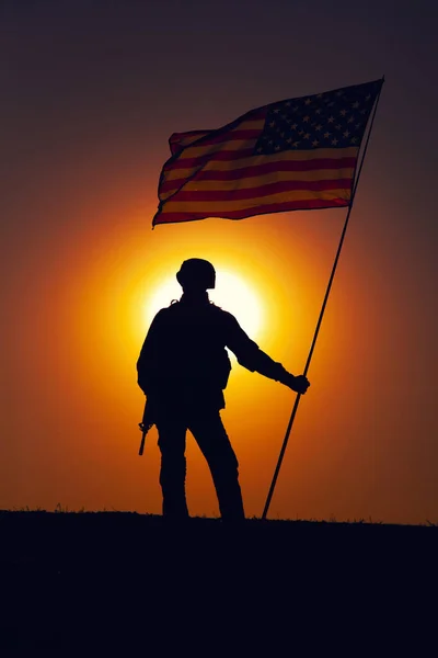 Soldado del ejército de EE.UU. con bandera en el fondo del atardecer — Foto de Stock