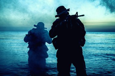 Suda yürüyen ve nişan alan komando askerleri