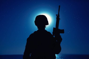 Tüfekli askerin gece silueti.