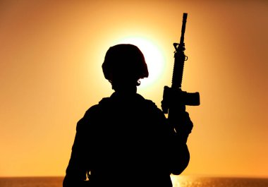 Denizci nişancı silueti günbatımının arkasında