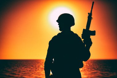 Denizci nişancı silueti günbatımının arkasında