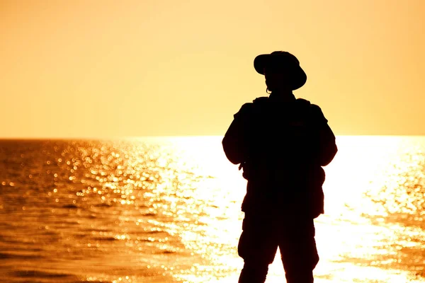 Coast guard soldier on sunset sea background