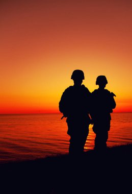 Sahil güvenlik askerleri deniz kıyısında devriye geziyor.