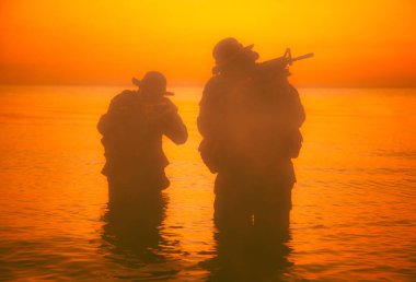 Suda yürüyen ve nişan alan komando askerleri