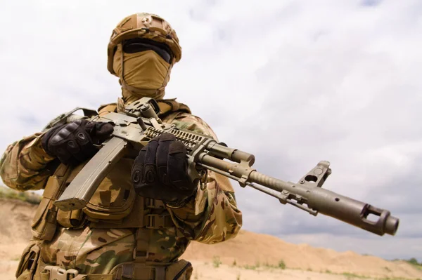 Armeesoldat hält Gewehr vor Himmelshintergrund — Stockfoto