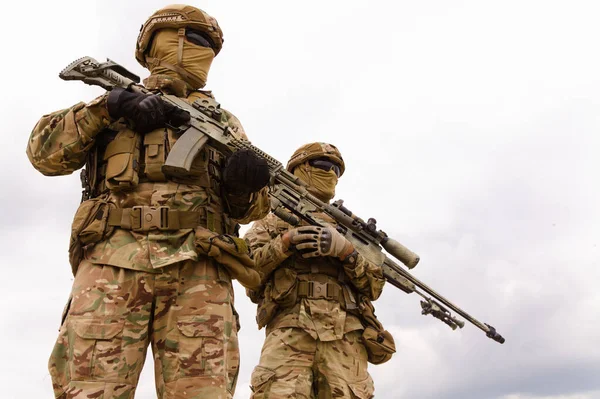 Two special forces soldiers against sky background