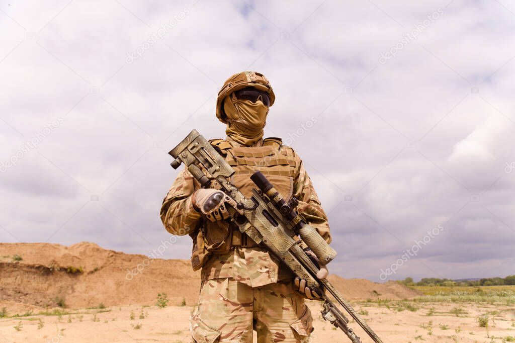 Equipped and armed special forces soldier in the desert