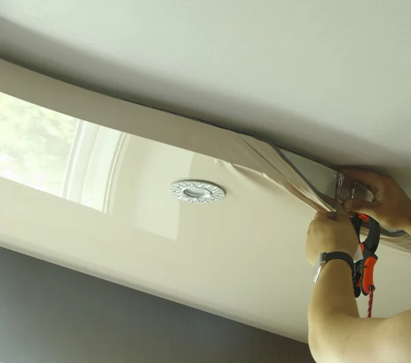 Master repairs stretch ceiling — Stock Photo, Image