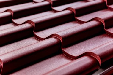 Kırmızı metalik çatı kiremitleri ve su damlaları.