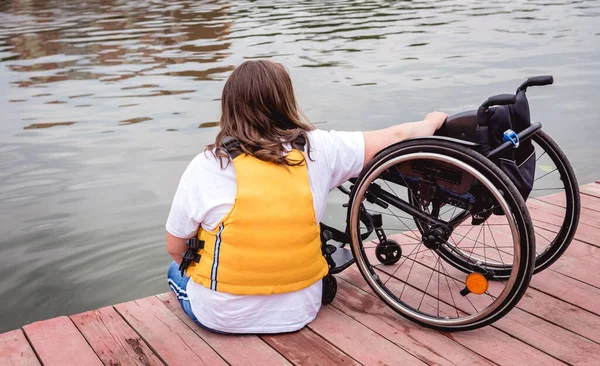 People with disabilities in life vests on the pier.